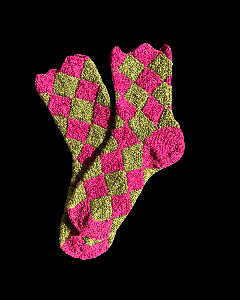 Pildil on paar käsitsi kootud sokke erksa roosa ja oliivrohelise ruudumustriga. Sokid on tekstuursed ja varvaste juures lainelise servaga.